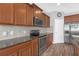 Modern kitchen featuring granite countertops, stainless steel appliances and warm wood cabinets at 662 Petal Mist Ln, Brooksville, FL 34604