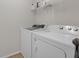 Well lit Laundry room featuring a white washer, dryer and wire shelving above at 662 Petal Mist Ln, Brooksville, FL 34604