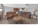 Open-concept living room with comfortable seating, wood-look floors, and a view of the kitchen at 662 Petal Mist Ln, Brooksville, FL 34604