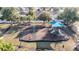 Aerial view of a neighborhood playground with slides and play equipment surrounded by trees at 662 Petal Mist Ln, Brooksville, FL 34604