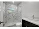 Updated bathroom with white marble shower, and dark vanity at 6703 N Boulevard, Tampa, FL 33604