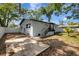 Exterior of the home featuring a light blue paint job, black railings, and concrete patio at 6703 N Boulevard, Tampa, FL 33604