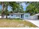 Light blue home with a well-maintained lawn and a new driveway and walkway at 6703 N Boulevard, Tampa, FL 33604