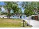 Charming light blue home with a well-maintained lawn, a new driveway, and mature trees at 6703 N Boulevard, Tampa, FL 33604