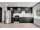 A modern kitchen with stainless steel appliances, sleek, dark cabinetry and white countertops at 6703 N Boulevard, Tampa, FL 33604