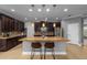 Open-concept kitchen with granite island, pendant lighting, stainless appliances, and dark wood cabinets at 7029 Dowling Mill Cir, Tampa, FL 33625