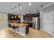 Modern kitchen features stainless steel appliances, dark cabinetry, tile backsplash, and granite island with seating at 7029 Dowling Mill Cir, Tampa, FL 33625