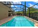 Screened-in pool area featuring lush landscaping and a cascading waterfall at 7029 Dowling Mill Cir, Tampa, FL 33625