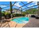 Screened-in pool area with a brick deck, chaise lounge, and lovely landscaping at 7029 Dowling Mill Cir, Tampa, FL 33625