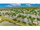 Aerial view of a residential neighborhood with a lake, lush greenery, and well-maintained homes at 7511 Turtle View Dr, Ruskin, FL 33573