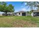Wide backyard with a well-maintained lawn, mature trees, and screened-in porch at 7511 Turtle View Dr, Ruskin, FL 33573