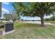 Expansive backyard featuring a lush lawn, mature trees, and tranquil water views at 7511 Turtle View Dr, Ruskin, FL 33573