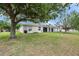 Spacious backyard with a well-maintained lawn and mature trees, perfect for outdoor activities at 7511 Turtle View Dr, Ruskin, FL 33573