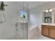 Modern bathroom featuring a glass shower, bathtub, wood vanity and decorative tile flooring at 7511 Turtle View Dr, Ruskin, FL 33573