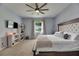 Bedroom featuring a ceiling fan, TV, shelving and a view of the outdoors from the window at 7511 Turtle View Dr, Ruskin, FL 33573