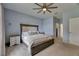Primary bedroom with a ceiling fan, upholstered headboard, and a hallway leading to a walk-in closet at 7511 Turtle View Dr, Ruskin, FL 33573