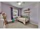 Charming bedroom with lavender walls, ceiling fan, and decor shelves; plush carpet and window included at 7511 Turtle View Dr, Ruskin, FL 33573