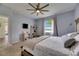 Bright bedroom with a window, ceiling fan and a comfy bed, plus a TV and shelving at 7511 Turtle View Dr, Ruskin, FL 33573