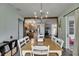 Dining room featuring modern chandelier, stylish wood floors, and view into kitchen and living room at 7511 Turtle View Dr, Ruskin, FL 33573