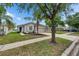 Charming single-story home featuring a well-manicured lawn, mature trees, and an attached two-car garage at 7511 Turtle View Dr, Ruskin, FL 33573