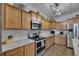 Bright kitchen with stainless steel appliances, wood-look tile floor and light wood cabinets at 7511 Turtle View Dr, Ruskin, FL 33573