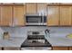 Kitchen features stainless steel appliances, granite countertops, and light wood cabinets at 7511 Turtle View Dr, Ruskin, FL 33573