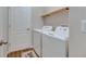 Clean laundry room featuring a stacked washer and dryer, with a shelf for storage at 7511 Turtle View Dr, Ruskin, FL 33573