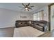 Well-lit living room featuring wood floors, a large leather sofa and a ceiling fan at 7511 Turtle View Dr, Ruskin, FL 33573