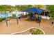 Shaded community playground with swings, a slide, play equipment, and seating, ideal for Gathering recreation at 7511 Turtle View Dr, Ruskin, FL 33573