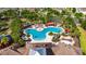 Overhead shot of a uniquely shaped community pool and lounge area, complete with lush palm trees and pergolas at 7511 Turtle View Dr, Ruskin, FL 33573