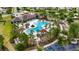 Aerial view of a community pool with lounge chairs, covered seating, landscaping, and an adjacent parking area at 7511 Turtle View Dr, Ruskin, FL 33573