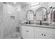 Elegant bathroom showcasing dual vanities, granite countertops, and a spacious walk-in shower with marble-look tile at 7889 3Rd S Ave, St Petersburg, FL 33707