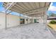 Covered patio area with stylish brick flooring, structural beams and walls of a white home at 7889 3Rd S Ave, St Petersburg, FL 33707