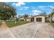 Charming single-story home with a well-maintained lawn, stone garden, long driveway, and a screened-in garage at 8141 82Nd Ave, Seminole, FL 33777