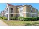 Well-maintained two-story apartment building with red roof, beige exterior and manicured landscaping at 9481 Highland Oak Dr # 313, Tampa, FL 33647