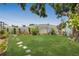 Landscaped backyard featuring lush lawn, stepping stones, and perimeter plantings at 226 75Th N St, St Petersburg, FL 33710