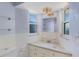 Compact bathroom with white tile, vanity, a decorative light fixture, and two windows at 226 75Th N St, St Petersburg, FL 33710
