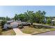 A single-story home with mature trees and a long driveway at 226 75Th N St, St Petersburg, FL 33710