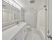 Well-lit bathroom with large mirror and vanity, and a bathtub with shower at 1011 Spindle Palm Way, Apollo Beach, FL 33572