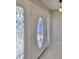 Front entrance with decorative glass details, tile floor, and a modern pendant light fixture at 1011 Spindle Palm Way, Apollo Beach, FL 33572