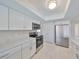 Updated kitchen with stainless steel appliances, plenty of white cabinetry, and modern countertops at 1011 Spindle Palm Way, Apollo Beach, FL 33572