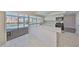 Well-lit kitchen with white cabinets, stainless steel appliances, quartz countertop, and a view of the pool area at 1011 Spindle Palm Way, Apollo Beach, FL 33572