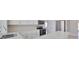 Modern kitchen with white cabinetry, stainless steel appliances, and quartz countertops at 1011 Spindle Palm Way, Apollo Beach, FL 33572