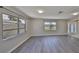 Bright living room with modern gray wood flooring and fresh neutral paint, illuminated by natural light through large windows at 1011 Spindle Palm Way, Apollo Beach, FL 33572