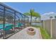 A delightful screened in pool and waterfront area featuring a lovely stone firepit at 1011 Spindle Palm Way, Apollo Beach, FL 33572