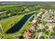 Scenic aerial view of a residential home with a picturesque lake and green surroundings at 10540 Carloway Hills Dr, Wimauma, FL 33598