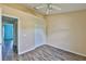 Neutral bedroom showcasing wood laminate floors, with a closet and a view of another room at 10540 Carloway Hills Dr, Wimauma, FL 33598