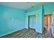 Bright bedroom with blue walls, wood-look floors, closet and natural light at 10540 Carloway Hills Dr, Wimauma, FL 33598