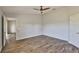 Neutral bedroom featuring a ceiling fan and wood-look flooring at 10540 Carloway Hills Dr, Wimauma, FL 33598