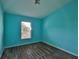 Cozy bedroom with blue walls, wood-look floors, and window views at 10540 Carloway Hills Dr, Wimauma, FL 33598